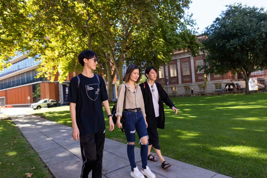 three students walking down path