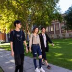 three students walking down path